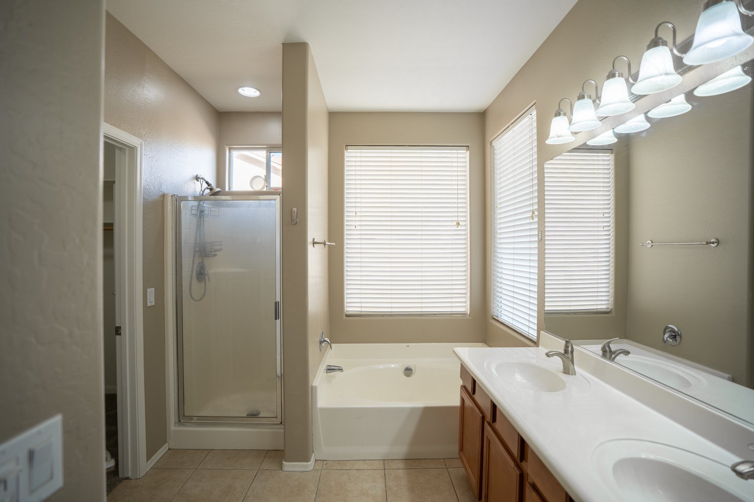Primary bathroom before: builder-grade shower stall, garden tub and oak vanity
